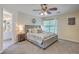 Bright bedroom featuring a gray upholstered bed, ceiling fan, and attached bathroom at 110 Moon Shadow Ln, Summerville, SC 29485