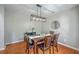 Elegant dining room boasts modern lighting, table setting, and rich hardwood floors at 110 Moon Shadow Ln, Summerville, SC 29485