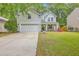 Charming two-story home with light gray siding, attached garage, well-manicured lawn, and a welcoming front porch at 110 Moon Shadow Ln, Summerville, SC 29485