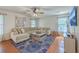Bright living room features a plush sectional sofa, hardwood flooring, and ceiling fan at 110 Moon Shadow Ln, Summerville, SC 29485