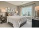 This bedroom has a decorative wall hanging, large window, and is decorated with two lamps and decorative pillows at 114 Headwater Dr, Summerville, SC 29486