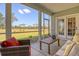 This screened patio features comfortable seating, a watering can, and a view of the manicured backyard at 114 Headwater Dr, Summerville, SC 29486