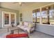 This screened patio is furnished with comfortable seating and has a view of the green backyard at 114 Headwater Dr, Summerville, SC 29486