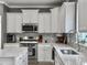 Bright kitchen features white cabinets, stainless steel appliances, and a quartz countertop at 115 Daniels Creek Cir, Goose Creek, SC 29445