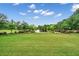 Expansive green lawn leading to a picturesque pond with a fountain, perfect for relaxation and enjoying nature at 120 Loon Dr, Summerville, SC 29483
