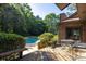 Wooden deck and patio with iron furniture, trees, greenery, and a swimming pool at 1218 Chersonese Round, Mount Pleasant, SC 29464