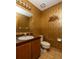 Small bathroom with brown accents and unique golden straw-like wallpaper and artwork on the wall at 1218 Chersonese Round, Mount Pleasant, SC 29464