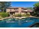 A backyard oasis featuring an in-ground pool reflecting the beautiful brick home and mature trees at 1218 Chersonese Round, Mount Pleasant, SC 29464