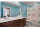 Bright, blue bathroom featuring a flip-flop shower curtain, wood vanity, and a long mirror at 130 Stagecoach Ave, Summerville, SC 29486