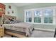 Bedroom featuring a large window with wooded views, soft green walls, and modern decor at 1348 Seaside Plantation Dr, Charleston, SC 29412