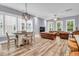 Open-concept living room with hardwood floors, large windows, and a comfortable leather sofa at 1348 Seaside Plantation Dr, Charleston, SC 29412