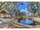 Community pond view surrounded by trees and houses, reflecting blue sky at 1348 Seaside Plantation Dr, Charleston, SC 29412