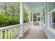 Spacious front porch featuring classic white railings and serene wooded views at 1348 Seaside Plantation Dr, Charleston, SC 29412