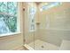 Modern walk-in shower featuring beige subway tile, a glass door, and a window at 1423 Clay Field Trl, Summerville, SC 29485