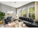 Bright living room featuring black leather sofas, a gold coffee table and neutral decor at 1543 Wando Landing St, Charleston, SC 29492