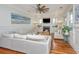 Cozy living room with a white sectional, fireplace, hardwood floors, and coastal decor at 1543 Wando Landing St, Charleston, SC 29492