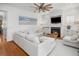 Bright living room with a white sectional sofa, fireplace, ceiling fan, and hardwood floors at 1543 Wando Landing St, Charleston, SC 29492