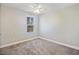 Bright bedroom featuring a ceiling fan and a window overlooking a tree-filled landscape, complemented by neutral carpet and paint at 164 Wappoo Trace Ln, Summerville, SC 29486