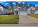 Charming two-story home with gray siding, an attached garage, a well-manicured lawn, and lush, mature trees at 164 Wappoo Trace Ln, Summerville, SC 29486