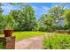 Brick-paved path in lush green backyard with mature trees and a brick retaining wall at 174 Revetment Ln, Mount Pleasant, SC 29464