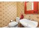 Quaint half bathroom with patterned wallpaper, a pedestal sink, and a decorative mirror at 174 Revetment Ln, Mount Pleasant, SC 29464
