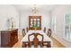 Formal dining room with hardwood floors, classic china cabinet, and bright natural light at 174 Revetment Ln, Mount Pleasant, SC 29464