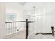 Bright hallway with decorative lighting, black railings, and an upper-level view to the main floor at 174 Revetment Ln, Mount Pleasant, SC 29464