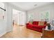 Comfortable living room featuring a bright red sofa, piano and access to the front door at 174 Revetment Ln, Mount Pleasant, SC 29464