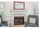 Close up on a cozy living room fireplace and armchairs with ample natural light at 174 Revetment Ln, Mount Pleasant, SC 29464