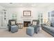 Cozy living room featuring a fireplace, blue armchairs, and ample natural light at 174 Revetment Ln, Mount Pleasant, SC 29464