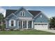 Charming blue house featuring white columns on front porch and a neatly manicured green lawn at 2020 Sea Water Dr, Charleston, SC 29412