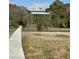 Secluded home with a metal roof surrounded by trees and marshland accessible by a wooden walkway at 211 Pelican Flight Dr # 1/6Th Share, Dewees Island, SC 29451