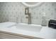Close-up of bathroom vanity featuring geometric accent wall, white countertop and brushed nickel faucet at 2177 Gulf Dr, Mount Pleasant, SC 29464