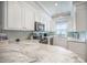 Well-lit kitchen featuring white cabinets, backsplash, and stainless steel appliances at 2177 Gulf Dr, Mount Pleasant, SC 29464