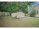 A backyard shed with double doors, surrounded by green grass, the house and fence at 2177 Gulf Dr, Mount Pleasant, SC 29464