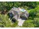 Aerial view of a brick home with a private backyard pool and lush landscaping, nestled among tall trees at 2221 Black Oak Ct, Mount Pleasant, SC 29466