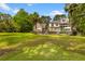 Expansive backyard featuring lush green lawn, mature trees, with home and pool in the background at 2221 Black Oak Ct, Mount Pleasant, SC 29466