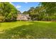 Expansive backyard featuring lush green lawn, mature trees, and a charming brick home with a pool at 2221 Black Oak Ct, Mount Pleasant, SC 29466