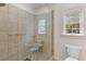 Bathroom featuring a glass-enclosed shower with tile walls, a built-in seat, and natural light from a window at 2221 Black Oak Ct, Mount Pleasant, SC 29466