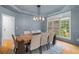 Formal dining room features wainscoting, chandelier, large window and seating for eight at 2221 Black Oak Ct, Mount Pleasant, SC 29466