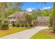 Stately brick home with a well-manicured lawn and long driveway, surrounded by lush trees under a blue sky at 2221 Black Oak Ct, Mount Pleasant, SC 29466