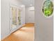 Hallway with hardwood floors, elegant French doors, and a unique circular window offering exterior views at 2221 Black Oak Ct, Mount Pleasant, SC 29466