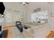 Cozy living room with a fireplace, large windows, and hardwood floors, adjacent to an open-concept kitchen at 2221 Black Oak Ct, Mount Pleasant, SC 29466
