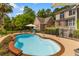 Gorgeous pool surrounded by a brick border and fence, nestled among lush greenery and palm trees at 2221 Black Oak Ct, Mount Pleasant, SC 29466