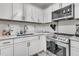 Close-up of a well-lit kitchen featuring white cabinets, stainless steel appliances, and modern countertop at 242 Amy Dr, Goose Creek, SC 29445