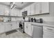 Updated kitchen with white cabinets, countertops, stainless steel appliances, and tile floors for a modern look at 242 Amy Dr, Goose Creek, SC 29445