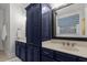 This bathroom features striking blue cabinets, light countertops and double sinks, offering a stylish and functional space at 2792 River Vista Way, Mount Pleasant, SC 29466