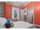 Stylish bedroom featuring orange walls, white bedding and hardwood floors providing a warm and inviting atmosphere at 2792 River Vista Way, Mount Pleasant, SC 29466