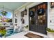 Charming front porch with porch swing, rocking chair and decorative entrance door at 2792 River Vista Way, Mount Pleasant, SC 29466