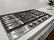 Stainless steel kitchen aid gas cooktop with white countertops and white subway tile backsplash at 2792 River Vista Way, Mount Pleasant, SC 29466